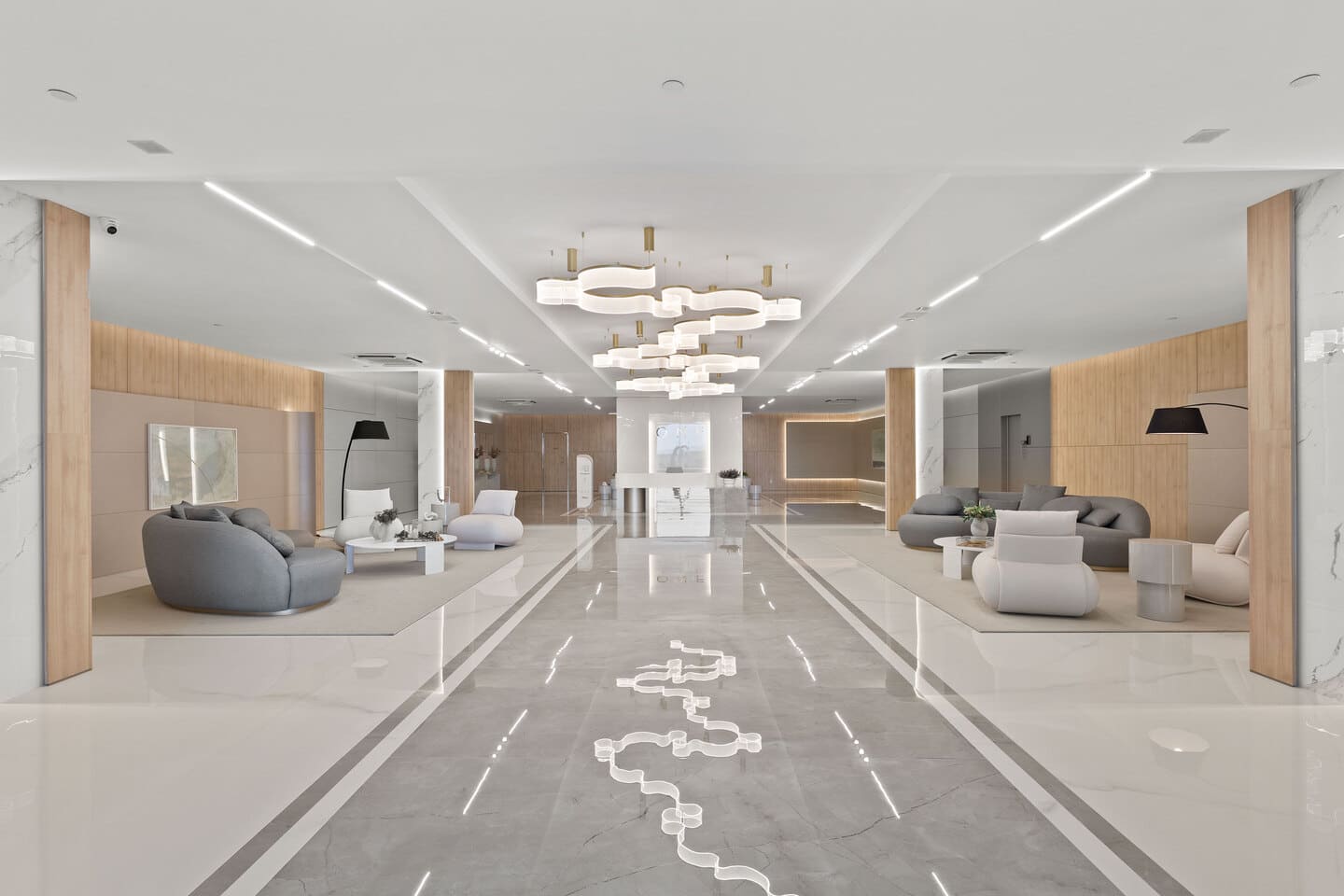 Monumental entrance atrium with high ceiling, noble stone flooring, and sinuous light sculptures