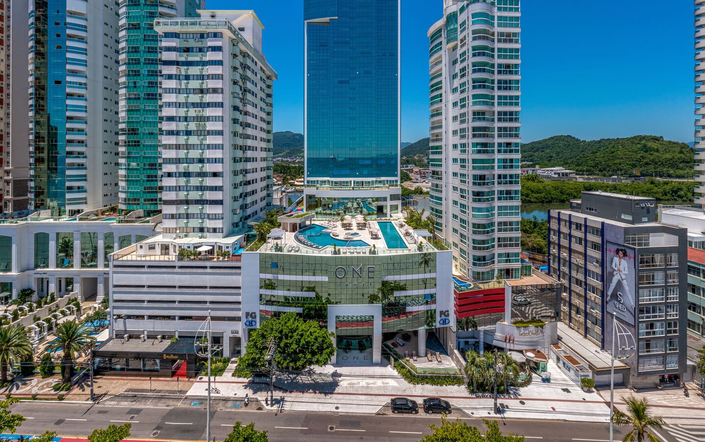 Podium facade and base of One Tower featuring curtain wall glazing and monumental entrance facing Avenida Atlântica