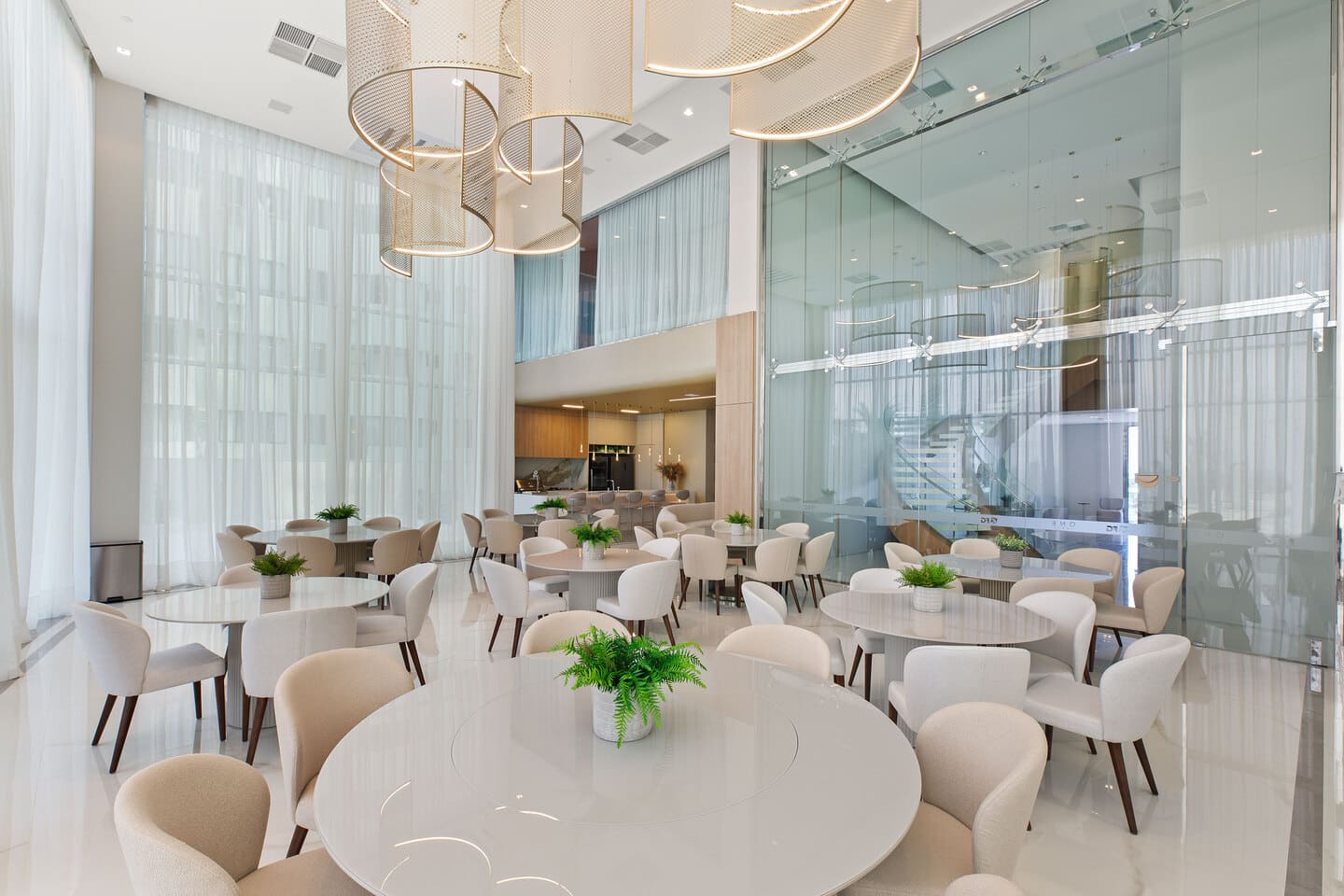 Grand ballroom with double-height ceiling, sculptural metallic mesh chandeliers, and elegant reception tables