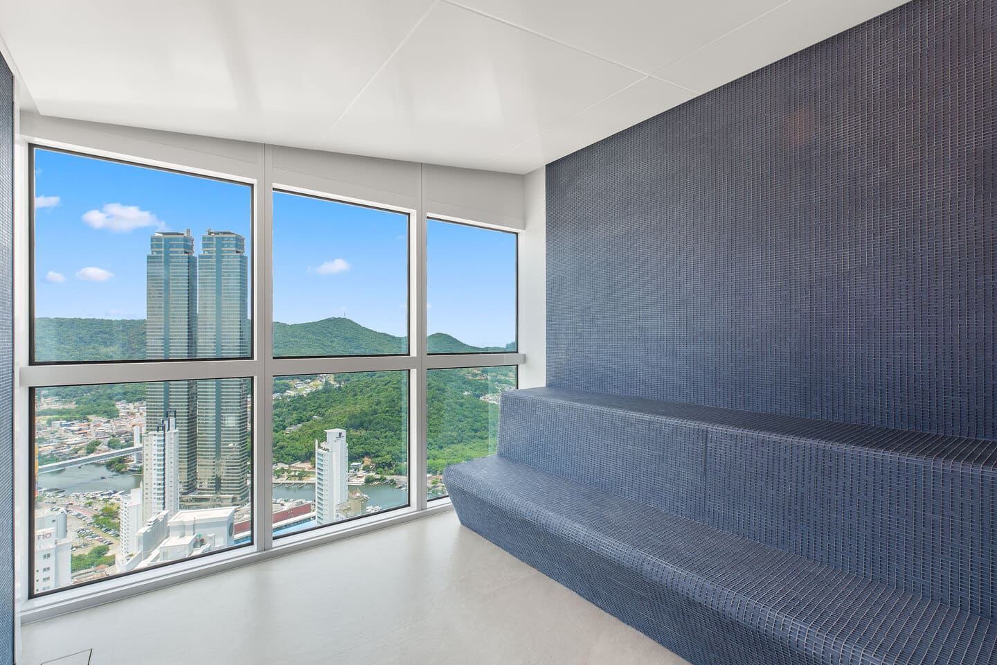 Sauna úmida contemporânea em pastilhas escuras com visor panorâmico de vidro voltado para a Marina Tedesco