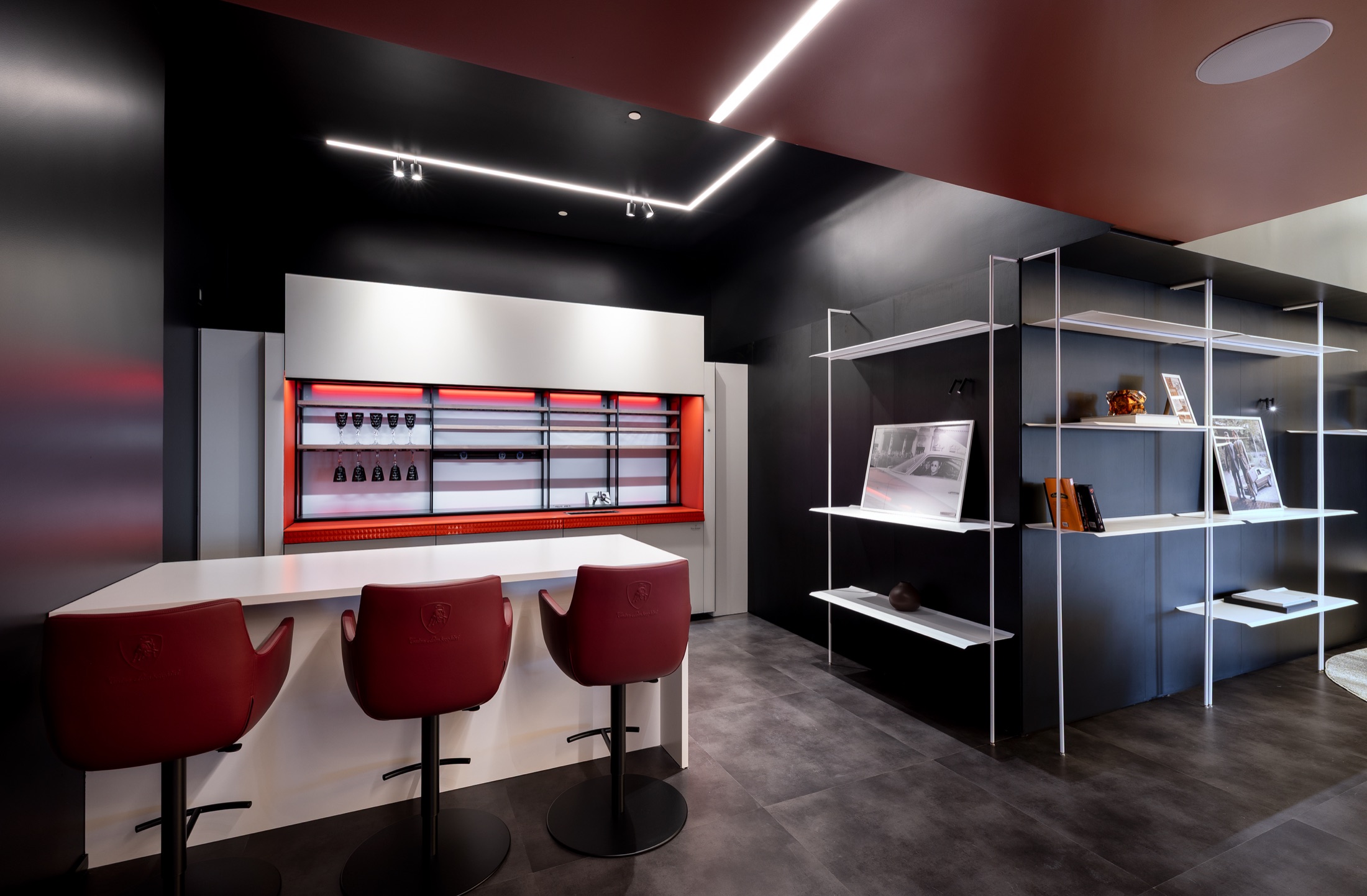 Fotografía real del Tonino Lamborghini Lounge con sillones italianos en cuero, piano de cola al fondo y retrato histórico de la familia Lamborghini